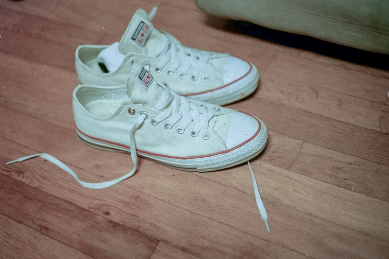 an empty pair of shoes laying on top of a wood floor