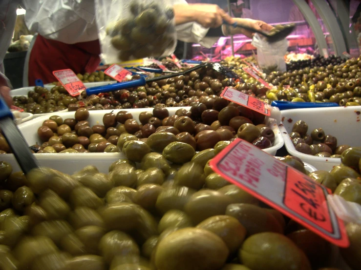 large trays full of green olives in a market