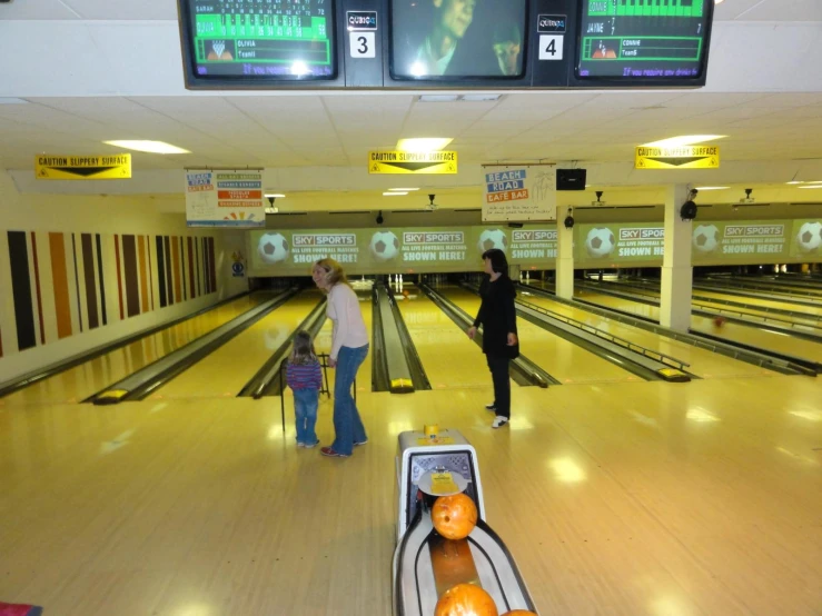 two people standing in front of a bowling alley