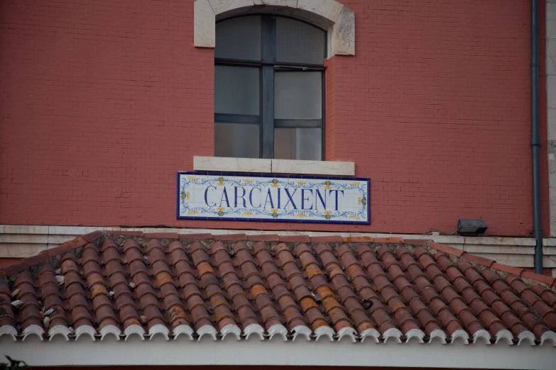 a sign for a el in front of a red building