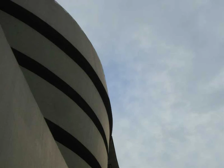 an airplane flying over a circular structure on a cloudy day