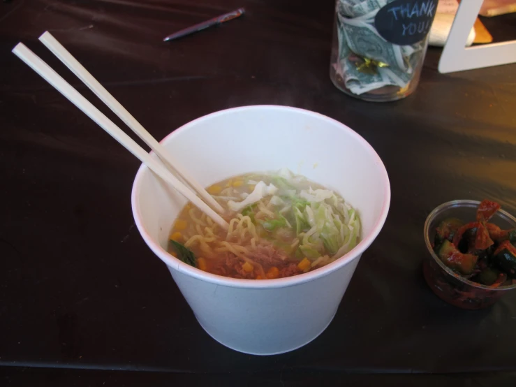 a bowl with some noodles and some chopsticks