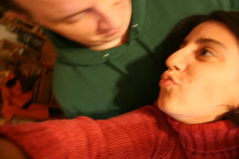 a man sitting next to a woman with a cell phone in her hand