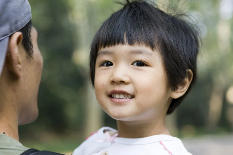 a little girl smiles as someone looks on