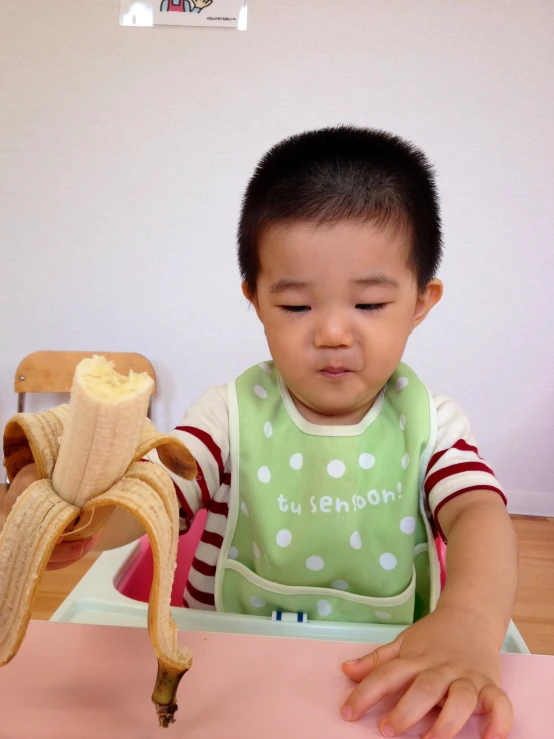 the small child has a banana on his plate