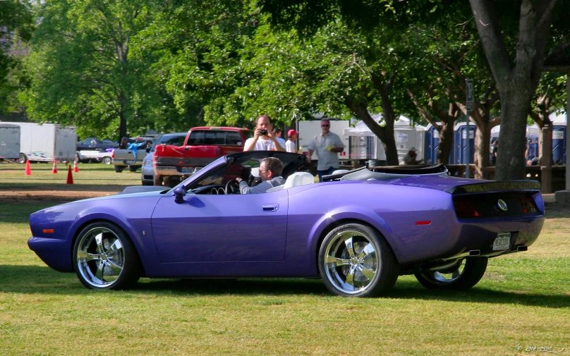 a purple sports car is parked at the car show