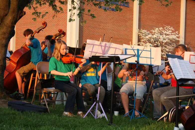 a group of people playing instruments in front of a brick building