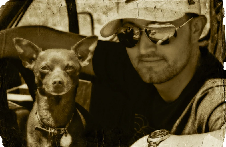 a man and a small dog sitting in the back seat of a car