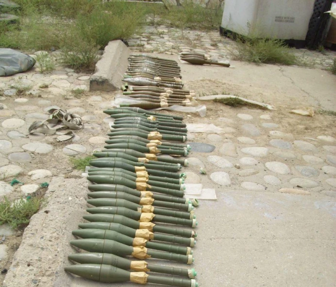 rows of bullet shells on dirt ground next to stones
