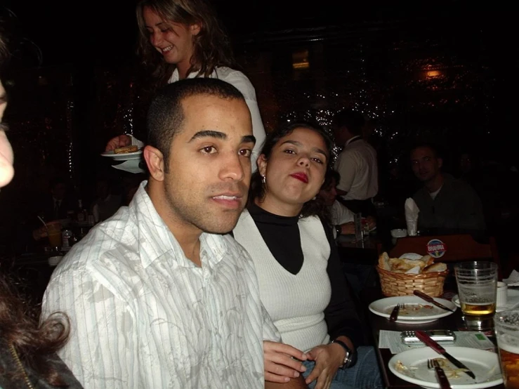 a group of people at a dinner table at night