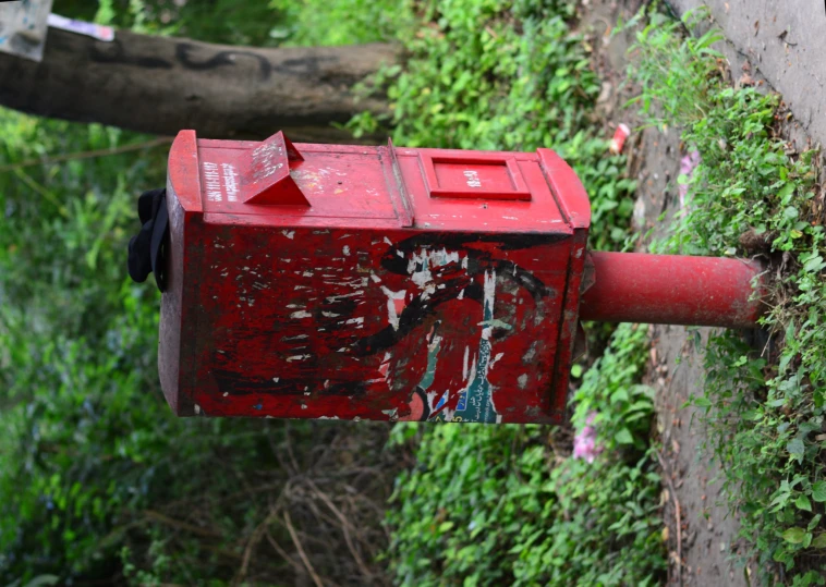 an old red mailbox sitting on the ground