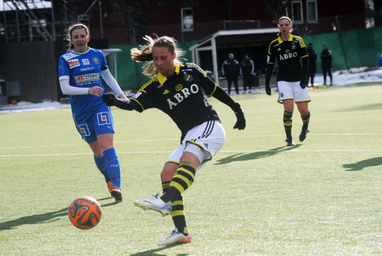 two girls on opposite teams compete for a soccer ball