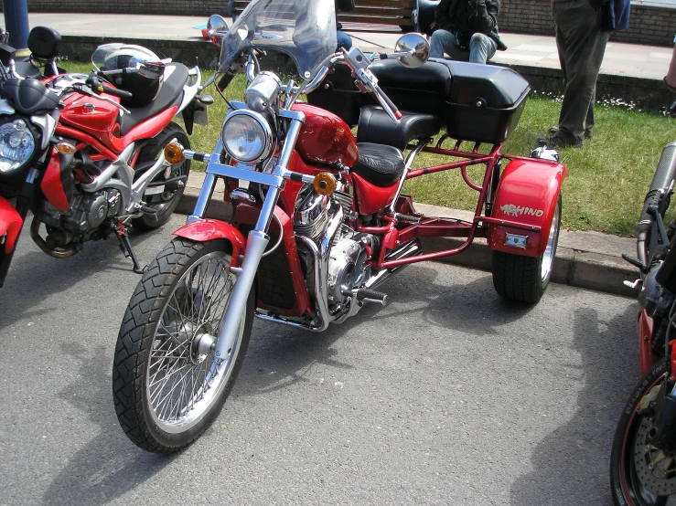 a red motorcycle is parked beside other red motorcycles