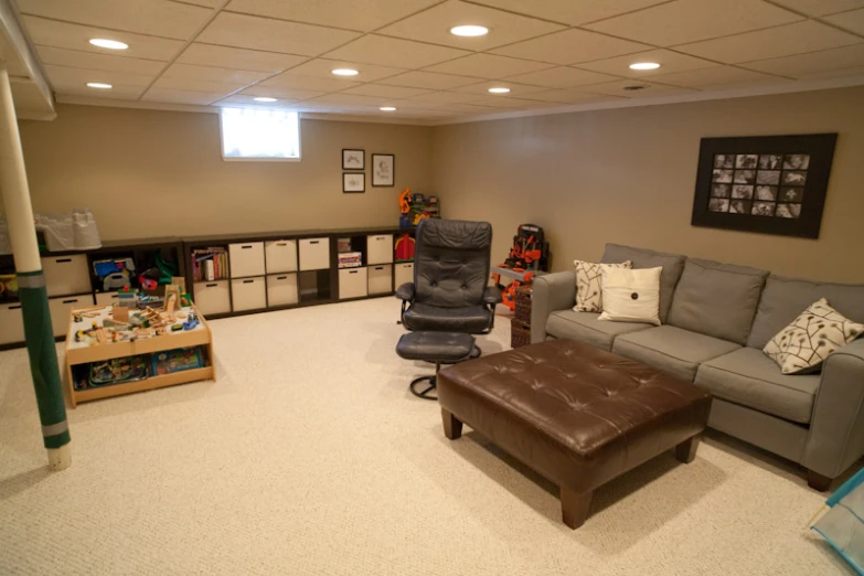 a living room with lots of gray furniture and pictures