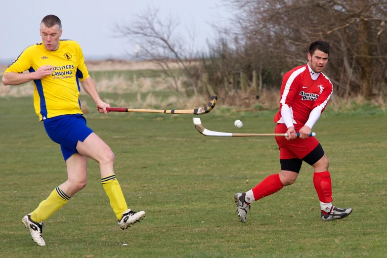 a man is swinging a stick in front of another man