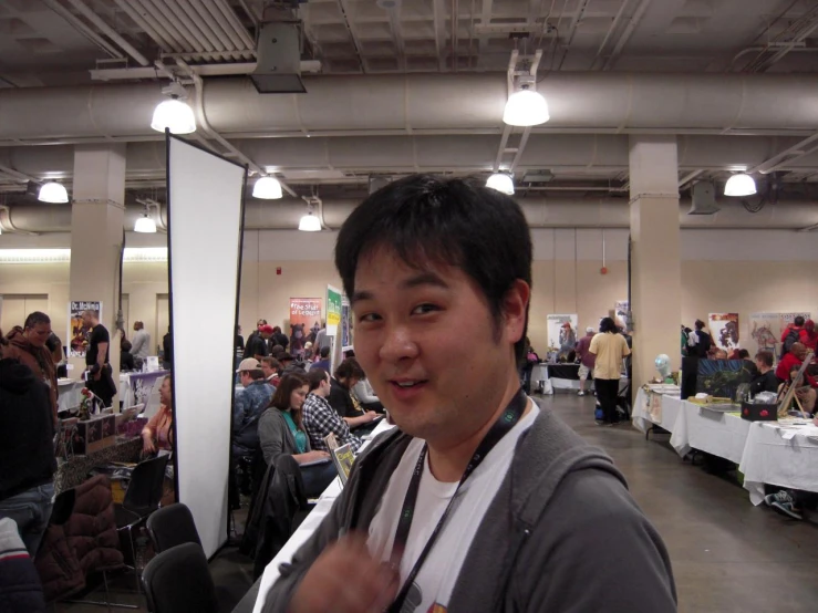 a man with a camera in his hands, surrounded by tables and chairs