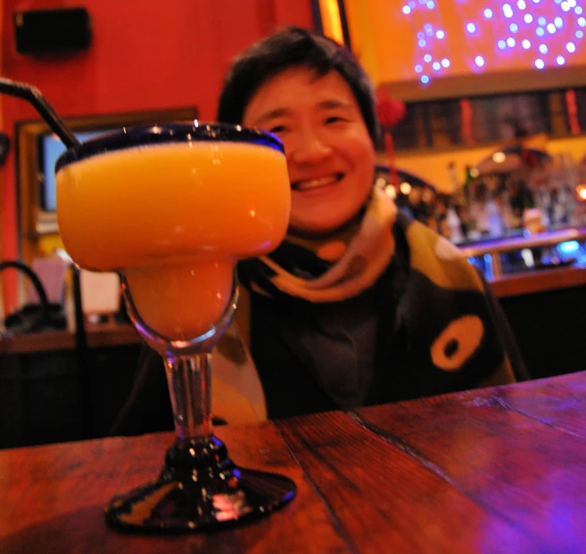 a woman poses with a beverage in her glass