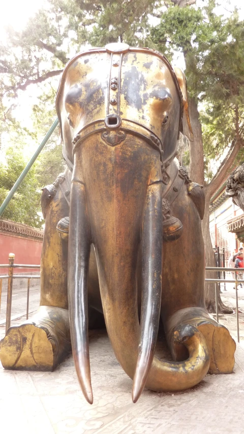 the large elephant is bronze and has its mouth open