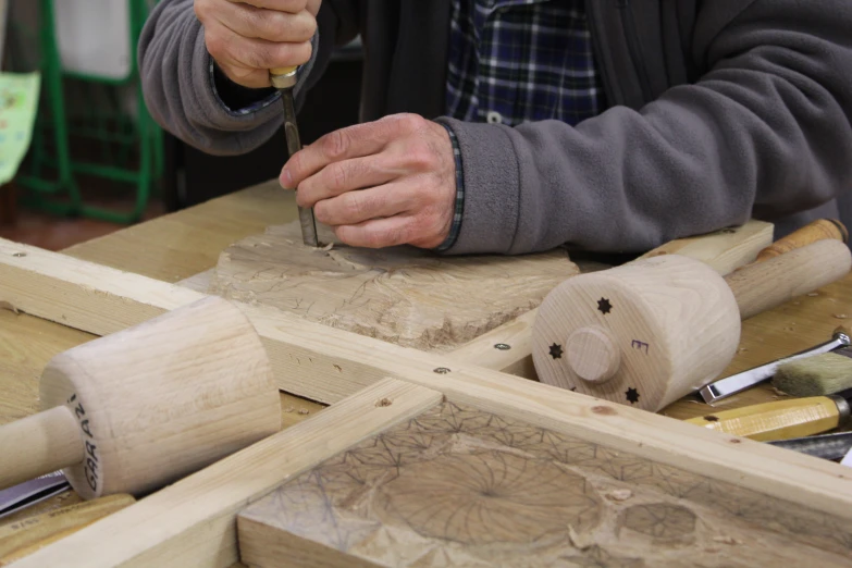 a man carving wood for a sculpture is shown