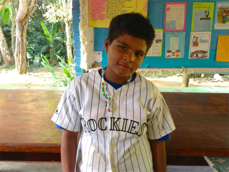 a boy posing in a baseball uniform for a po