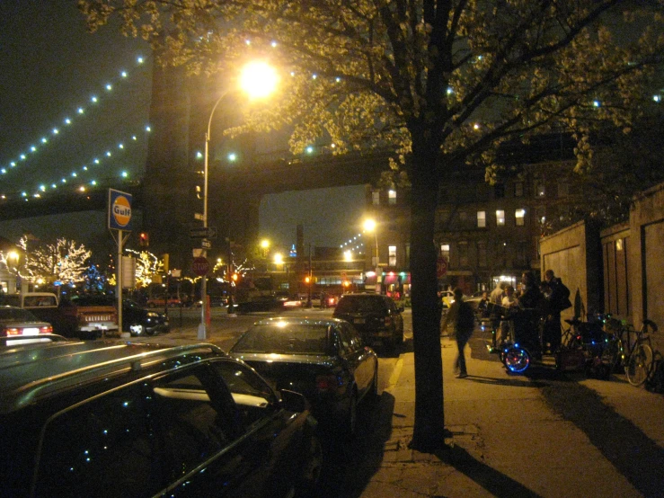 a night scene showing an apartment building at the edge of a busy street