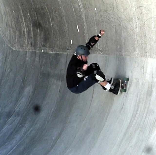 a man with skateboard is riding in a bowl