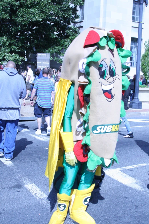 a large green and yellow mascot with a large bag on its back