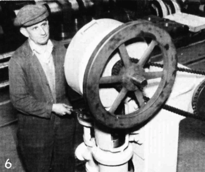 a man looks up at the wheel on a large ship