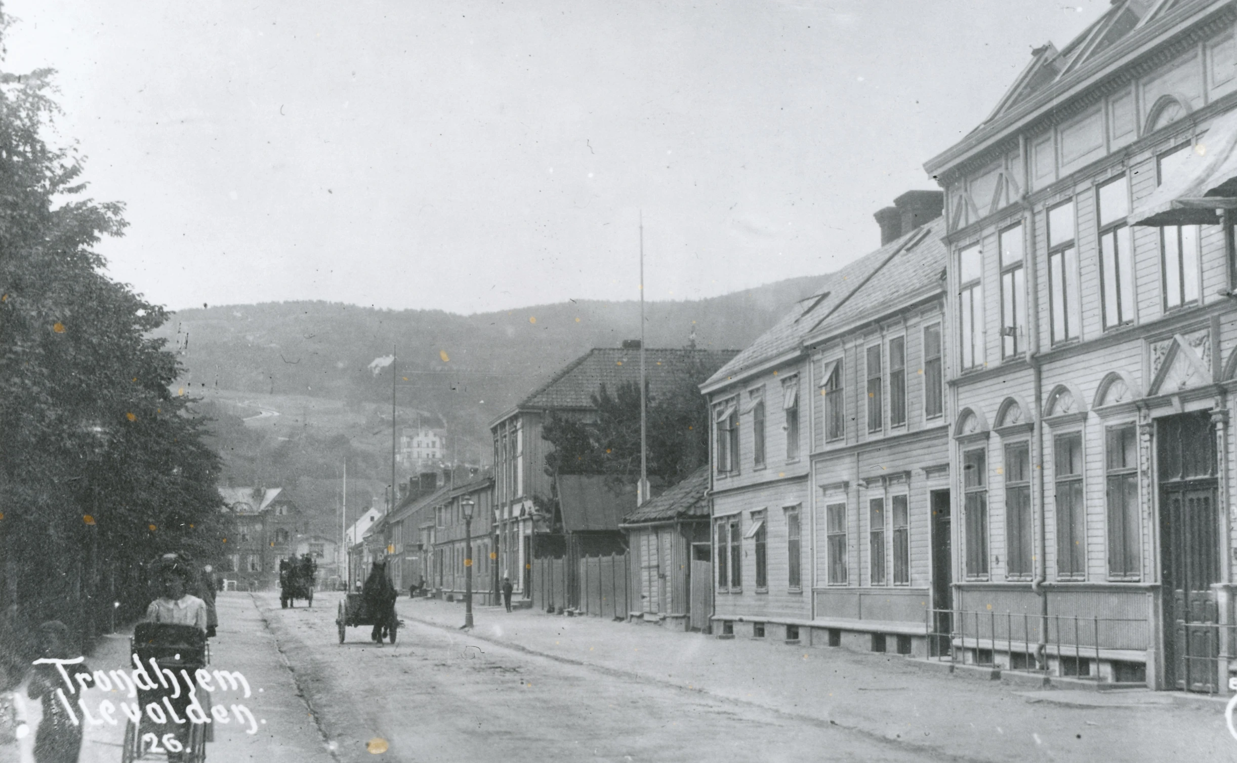 this is a black and white po of people walking down the street in an old time town