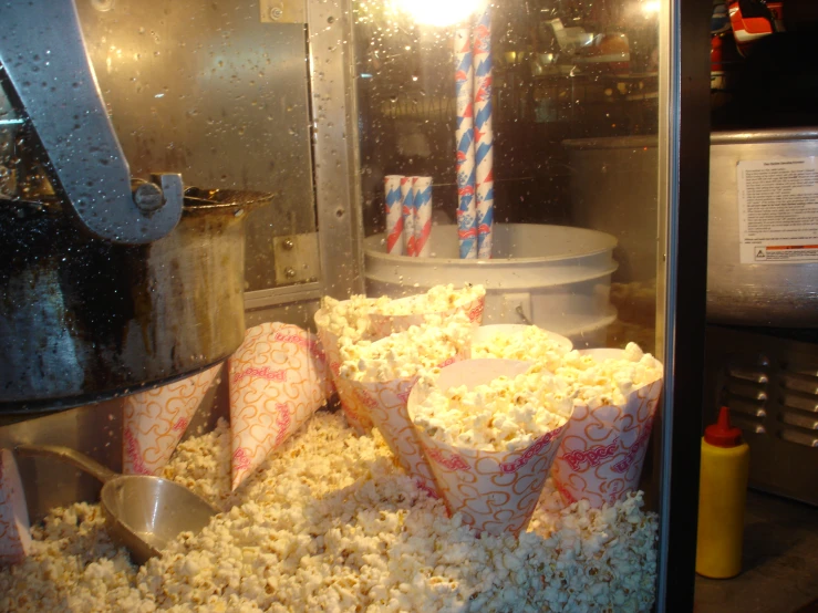 a close up of popcorn buckets on the conveyor belt