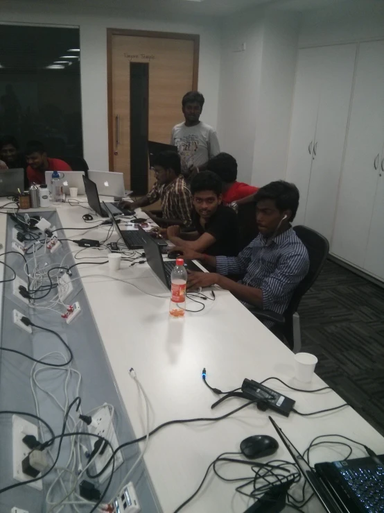 a group of people sitting in front of desk with computers