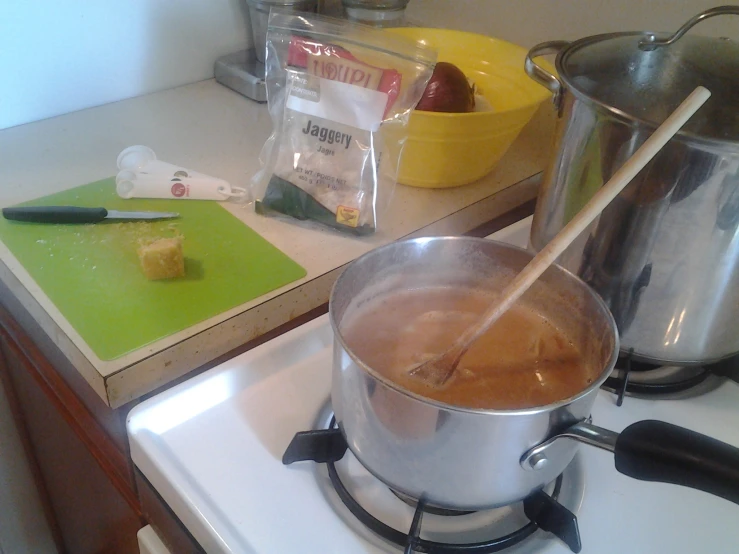 a kitchen counter with a silver pot and utensils in it