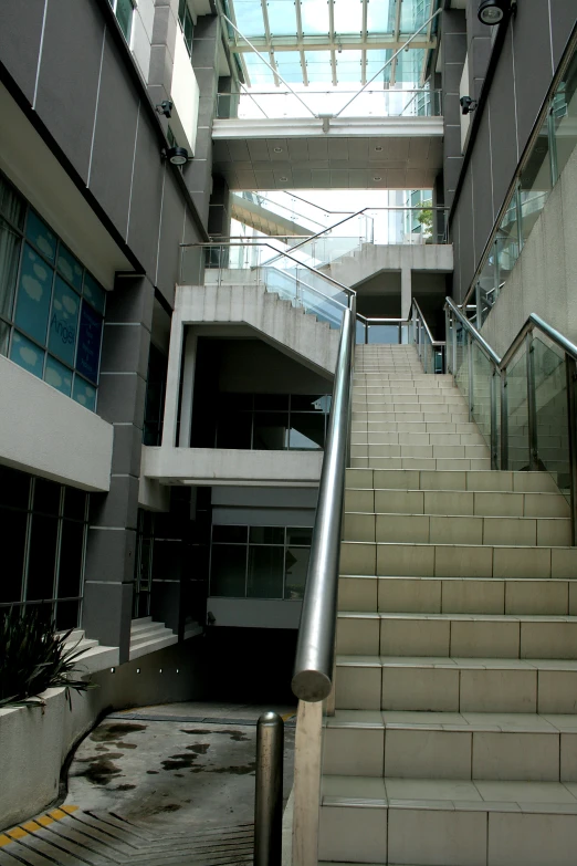 a stair case in a modern building has glass and brick walls