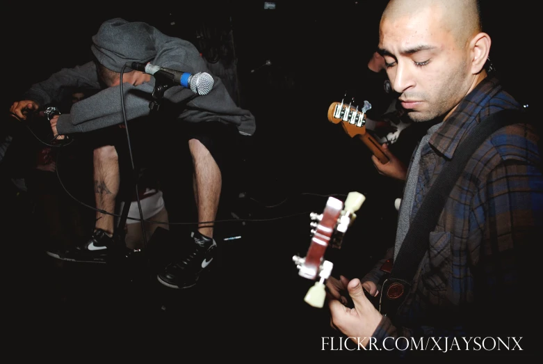 the man is playing a guitar in the dark