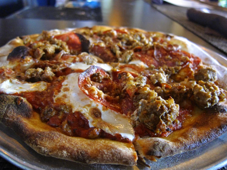 a large pizza with lots of toppings sits on a plate