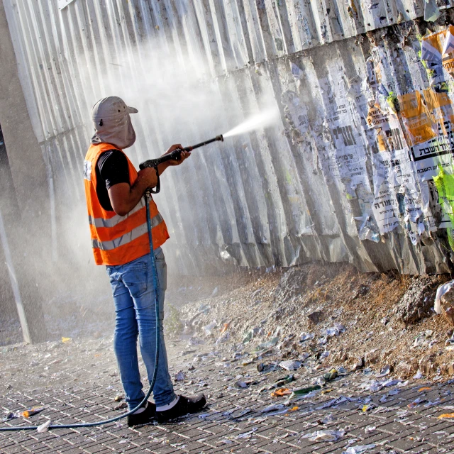 a man spraying pest from an outdoor fire hydrant