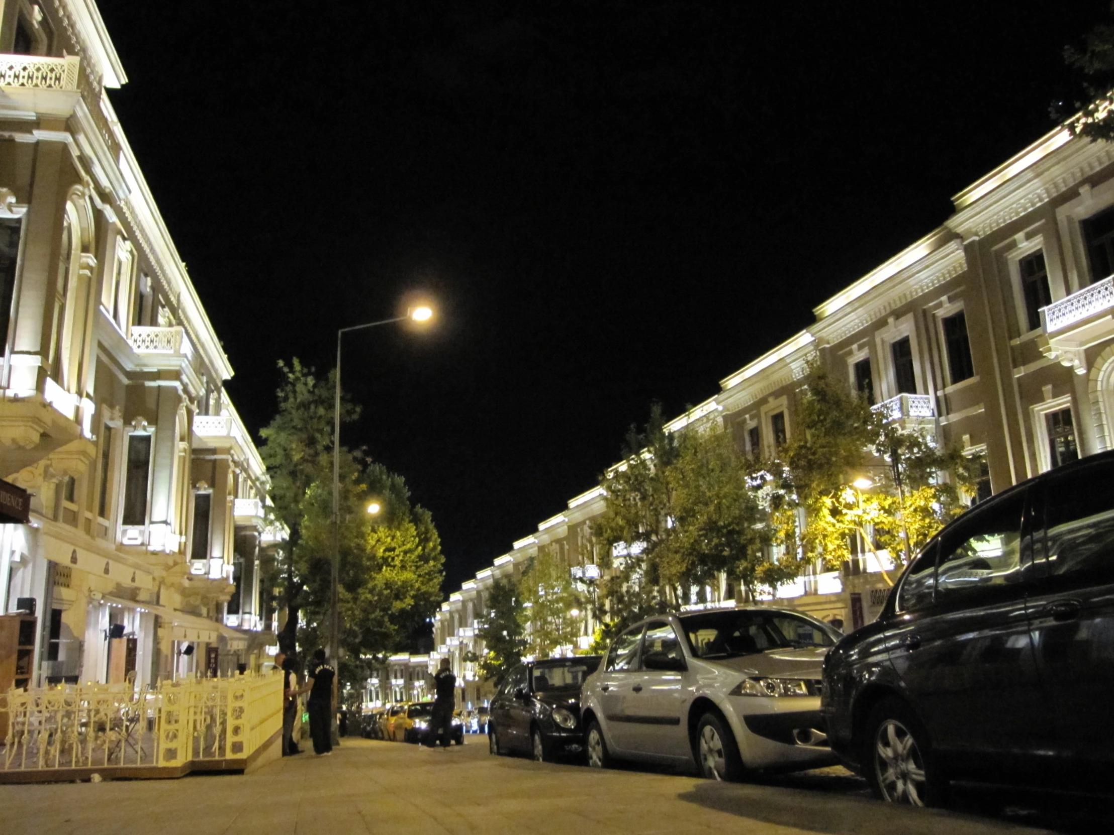 night time city street scene of cars parked in street