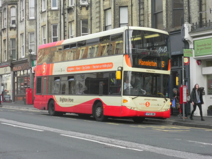 a red and white double decker bus on the street