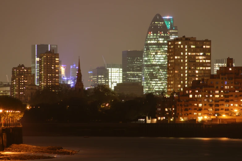 a group of buildings lit up by lights on top of a body of water