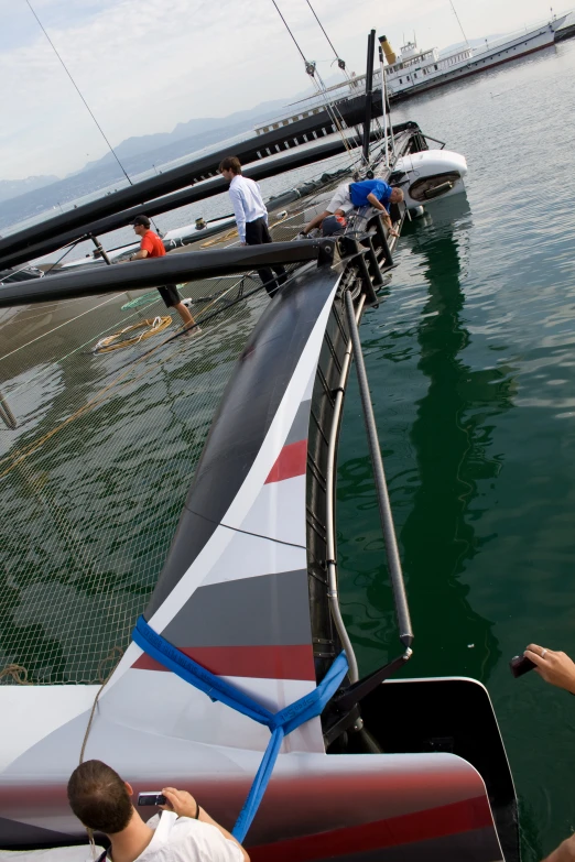 the people are looking at the water on the sailboat