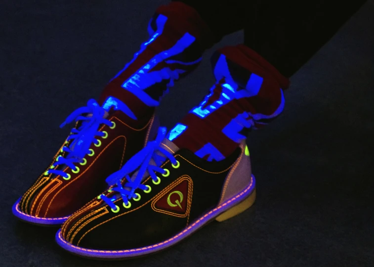 a pair of dark sneakers glowing in blue and yellow