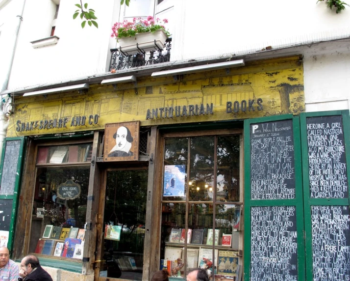 people sitting outside the entrance to an old book store