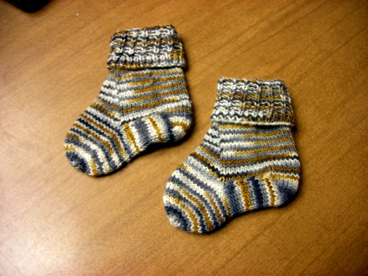 two knit socks that are sitting on a table