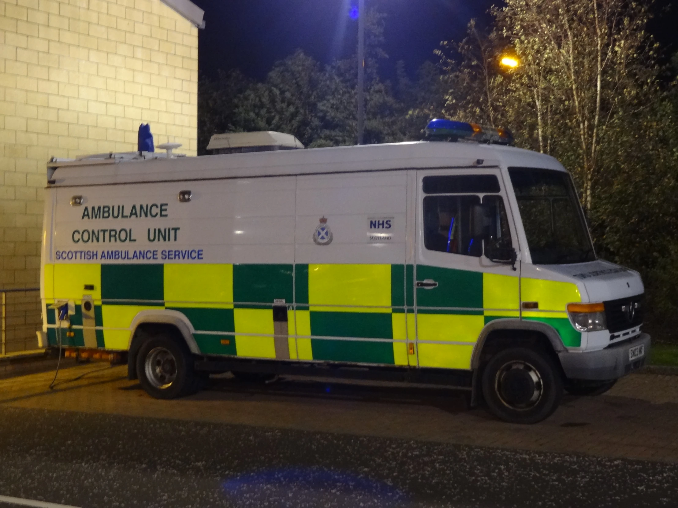 an ambulance parked next to a wall at night