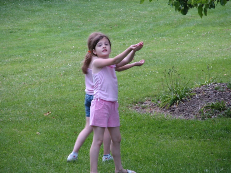 two small children are standing in the grass