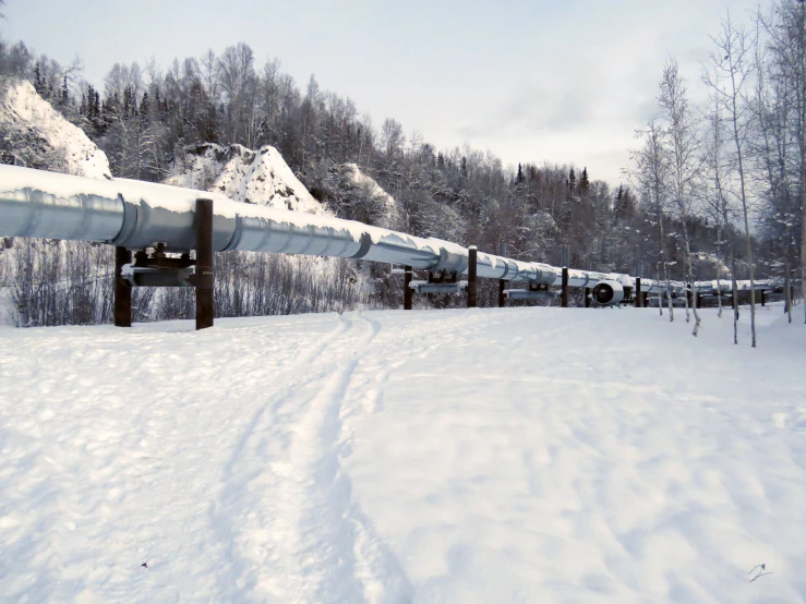 a snow covered mountain with a train on tracks
