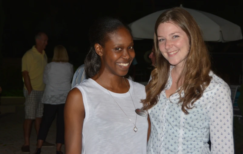 two women standing next to each other and smiling