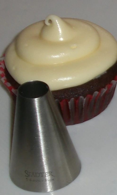 a cupcake is sitting next to a pastry cutter