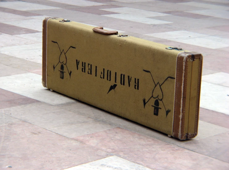 an old suitcase on the ground with a marker