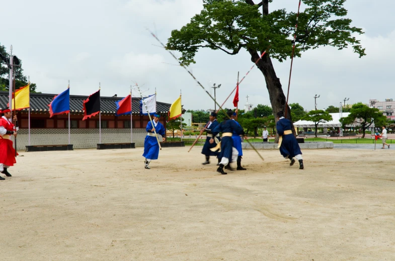 some people in blue outfits marching and holding flags